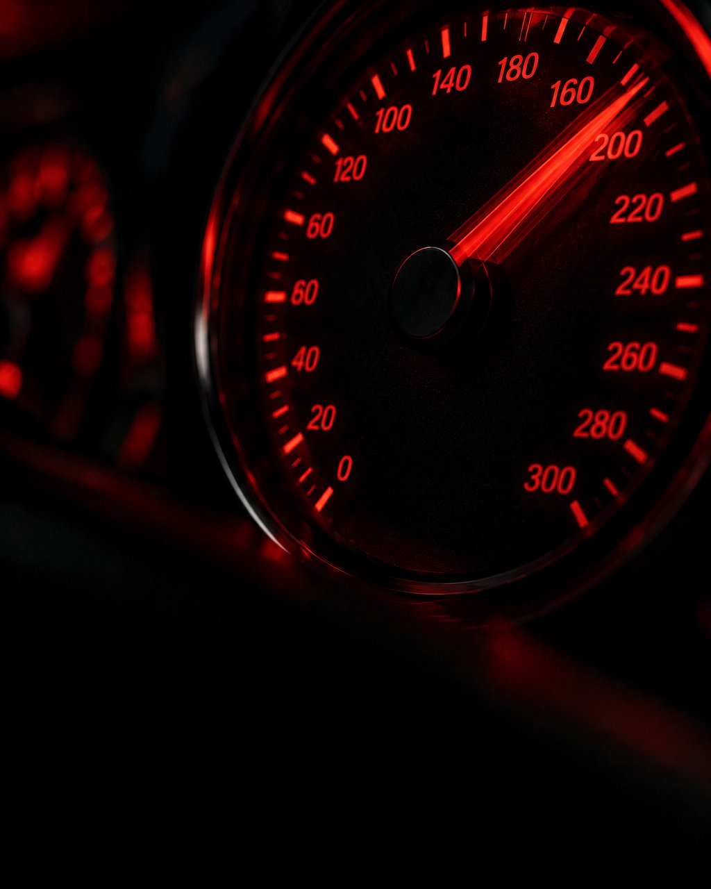 A speedometer needle sweeping past 200, lit red